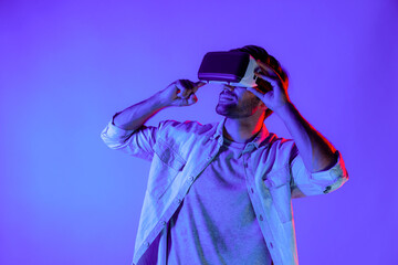 Caucasian man enter metaverse by using virtual digital goggles while standing look in cyberspace...
