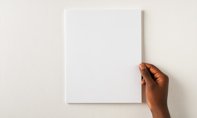 Obraz premium Hand Holding Blank White Canvas Against Textured Wall. mockup white Paper sheet