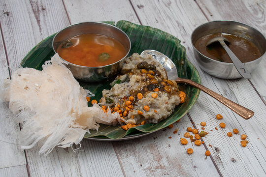 South Indian platter serving pongal and rasam,  gooseberry gravy,  along with starch dosa