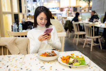Woman take photo on her dish in the restaurant