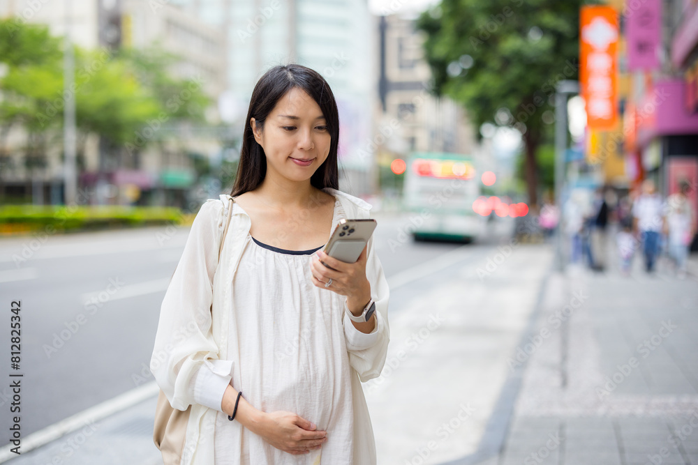 Canvas Prints Pregnant Woman use mobile phone in city