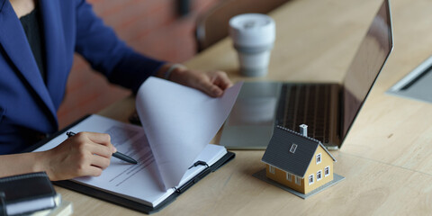 Interest and loan concept, woman is calculating house interest with documents.