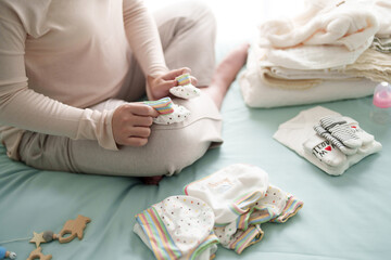 Pregnant woman preparing her baby clothes for maternity at hospital