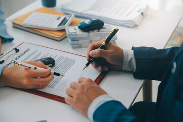 Insurance officers hand over the car keys after the tenant. have signed an auto insurance document...