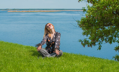 Energy healing and meditation concept, woman on a grass chilling and resting outside