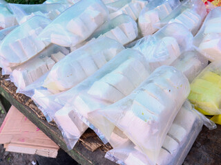 Plastic bags containing raw white tofu are sold at traditional markets