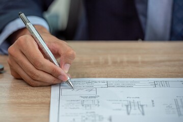 A businessman in a suit signs a contract.