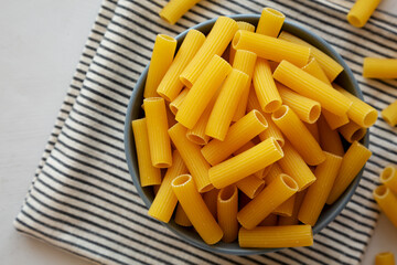 Dry Rigatoni Pasta in a Bowl, top view. Flat lay, overhead, from above. Copy space.