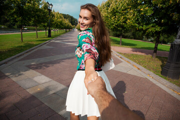 Follow me, Beautiful young woman holds the hand of a man
