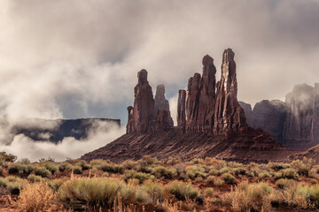 Fragile Monument Valley spires next to the Famous Totem Pole during a very stormy, eerie day.