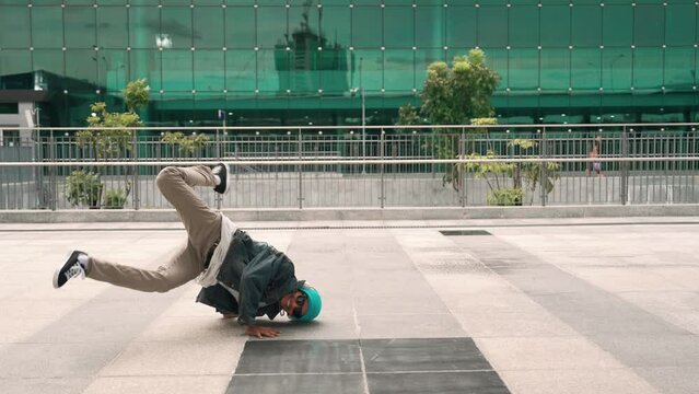 Happy hipster listen to hip hop music from headphone while dancing in lively mood. Professional street dancer perform b boy dancing at outdoor. Outdoor sport 2024. Modern lifestyle. Sprightly.