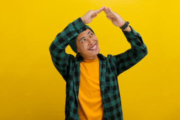 Happy Young Asian man with a beanie hat and casual clothes is making a hand gesture above his head,...