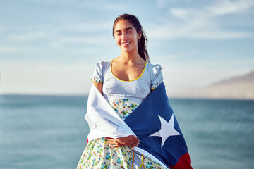 portrait beautiful latin woman holding over the shoulders a flag of Chile wearing national costume...