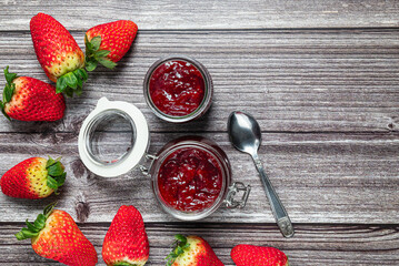 Tasty and healthy homemade strawberry jam. Top view of a table with a jar of homemade strawberry jam