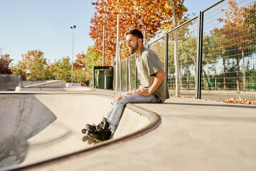 young skateboarder sitting on the kerb of an empty skatepark.