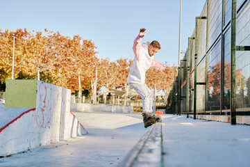aggressive roller skater performing a trick on a railing in skatepark