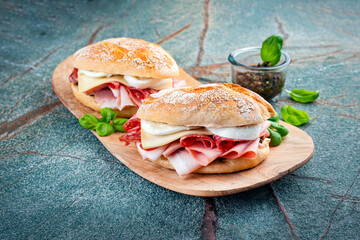 Traditional New Orleans muffaletta sandwiches with mortadella, salami and provolone cheese served...