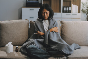 Upset woman frustrated by problem with work or relationships, sitting on couch, embracing knees,...