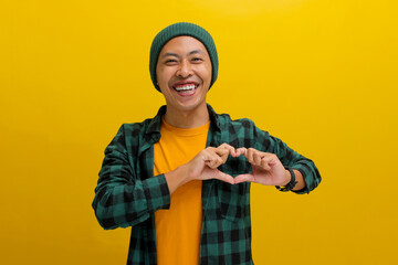 Attractive Asian man, dressed in a beanie hat and casual shirt, exudes happiness as he creates a...