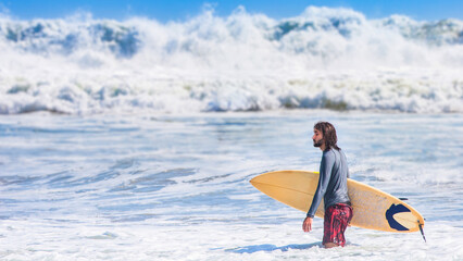 Man surfer stands in water. Boy with surfboard. Surfer near big wave. Tourist came to ocean. Man...