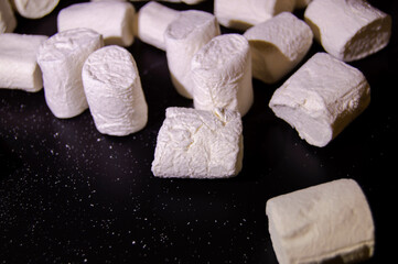 marshmallows ready to eat raw or warm, black background with pleasant warm light