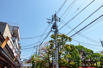 Electricity pole in Japan with power line cables against sky, Tokyo