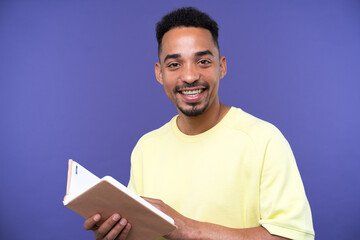 Emotional young black guy in casual raising fists up studio background, celebrating success
