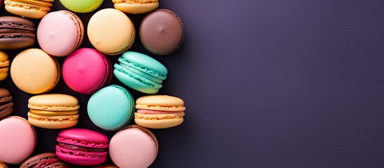 Obraz premium Top view of macarons or macaroons cookies arranged on a green background with a colorful and vibrant mix of colors in the image. Copyspace image