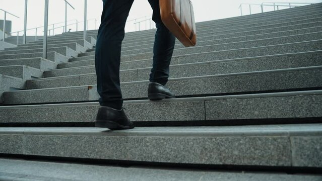 Top view of smart business man walking up stairs with bag in the hand. Professional project manager climb up the stair and going to workplace. Increasing skill, getting promotion, traveling. Exultant.