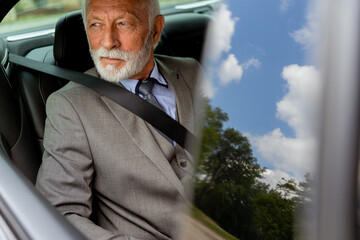 Distinguished senior gentleman enjoying a peaceful ride in a luxury car