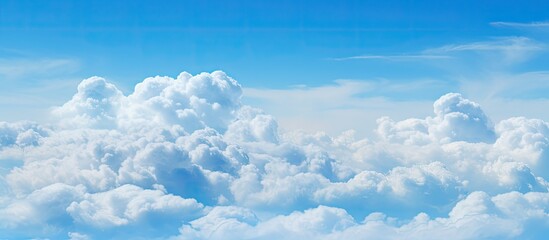 Copy space image of fluffy clouds set against a serene backdrop of a pale blue sky
