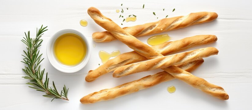 A flat lay image showcasing grissini breadsticks accompanied by olive oil on a plain white background allowing ample space for text