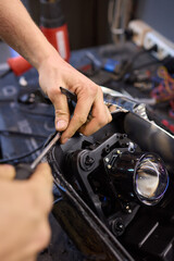 Fototapeta premium Person fixing Automotive lighting with screwdriver on Motor vehicle headlight