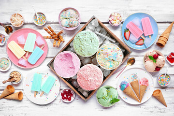 Cool summer food table scene. Assorted ice cream, popsicles and frozen treats. Pastel colors. Top...