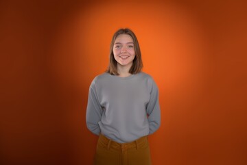 Fototapeta premium Smiling Teenage Girl on Orange Background. Generative AI.