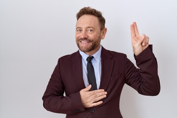 Middle age business man with beard wearing suit and tie smiling swearing with hand on chest and...