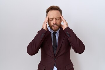 Middle age business man with beard wearing suit and tie with hand on head, headache because stress....