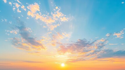 Naklejka premium Sunset sky with orange yellow light clouds. Colorful smooth blue sky gradient. Natural background of sunrise. Amazing heaven at morning. Slightly cloudy evening atmosphere. Wonderful weather on dawn.