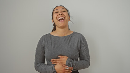 A joyful hispanic woman laughing heartily against an isolated white background, exuding happiness...