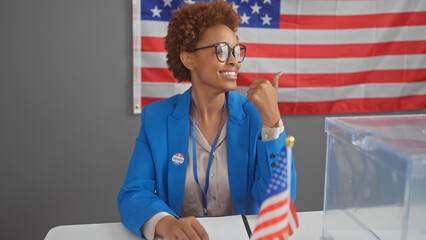 American woman smiles in electoral college interior with us flag and 'voted' sticker