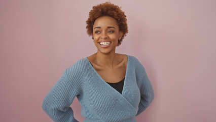 Smiling african american woman posing in front of a pink background, portraying confidence and...