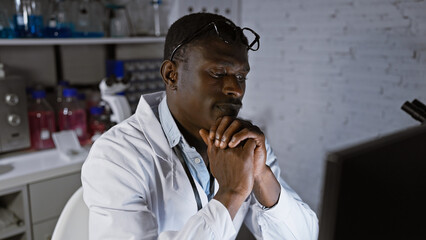 A contemplative african man in a laboratory setting, wearing glasses and a lab coat, surrounded by...