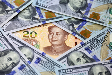 Chinese yuan banknote surrounded by US dollars. Concept of trade war between the China and USA,...