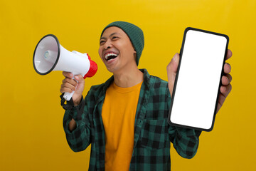 Excited Asian man shows a phone with an empty blank screen for copy space while holding a megaphone...