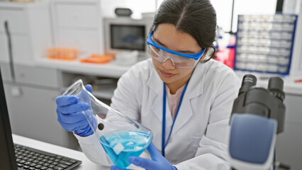 Hispanic woman scientist conducts experiment in laboratory setting, wearing safety goggles.