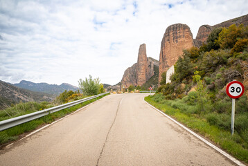 a paved road entering Las Penas de Riglos village, comarca of Hoya de Huesca, province of Huesca, Aragon, Spain