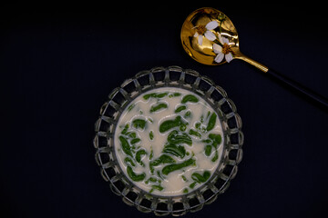 Lod Chong, Thai Dessert with black background. Lod Chong is famous Thai dessert with sweet taste made from palm sugar. Thai dessert serving with a spoon. Still-life food image with luxury dark theme