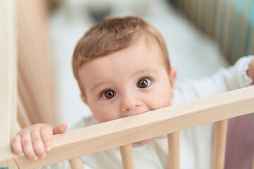 Adorable toddler sucking cradle at bedroom