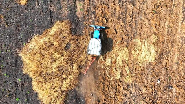 From above, a tractor maneuvers meticulously, its plow meticulously sculpting precise furrows in the saturated soil, laying the groundwork for agricultural productivity.
