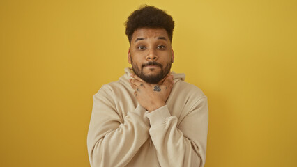 Obraz premium Portrait of a stylish adult man posing confidently against a solid yellow background